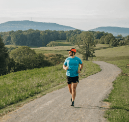Man with a hat running on a trail in Franklin County