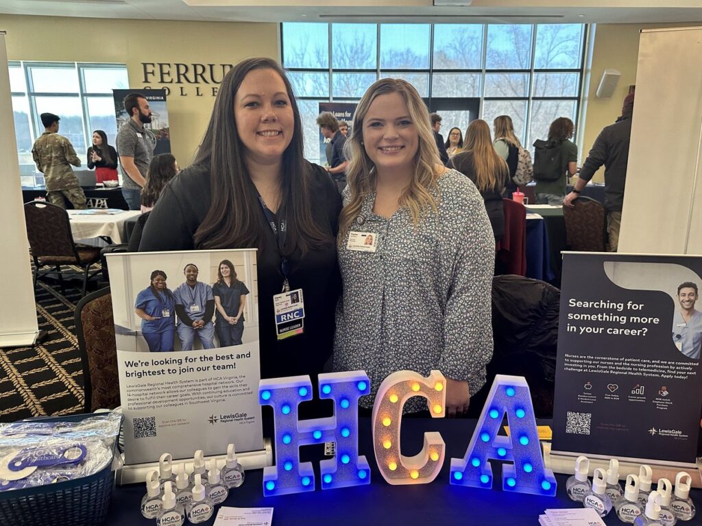 Two women from HCA Healthcare stand behind career information booth